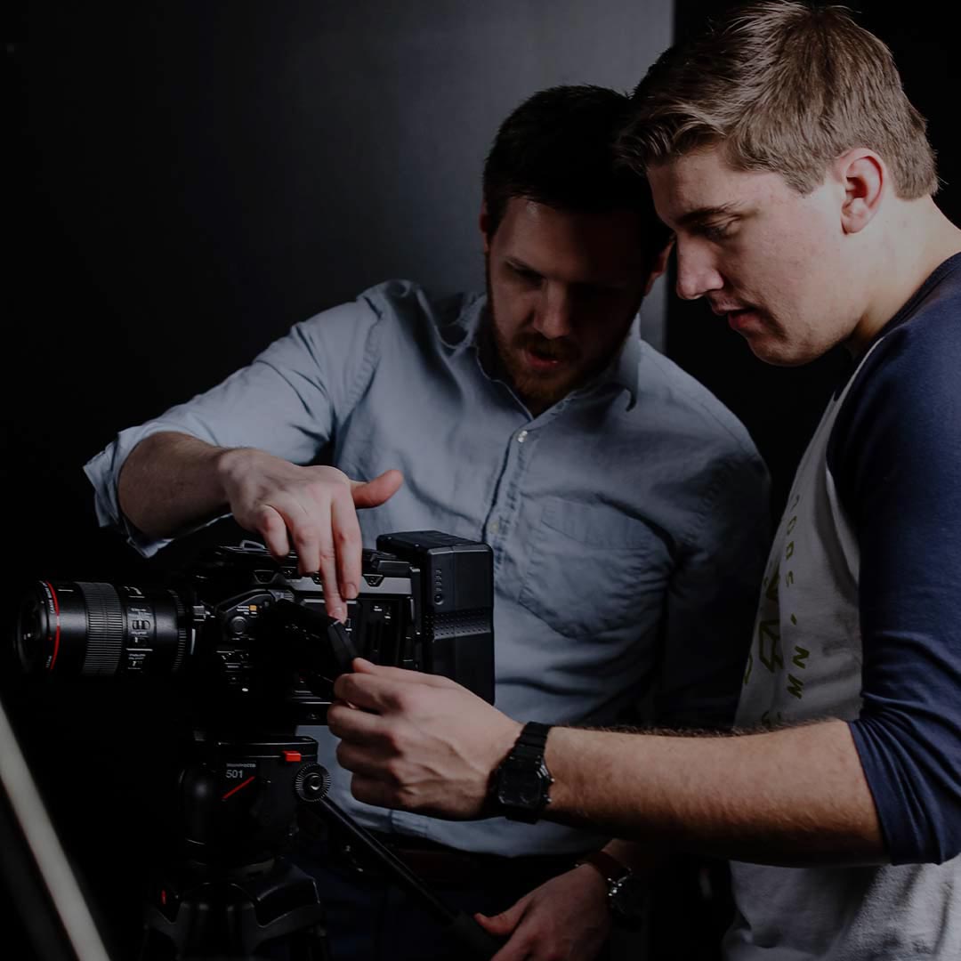 professor showing male student camera in class christian courses