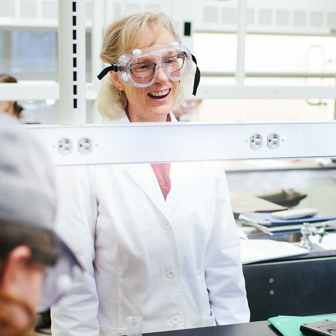 professor smiling in science clothes colleges with teaching majors