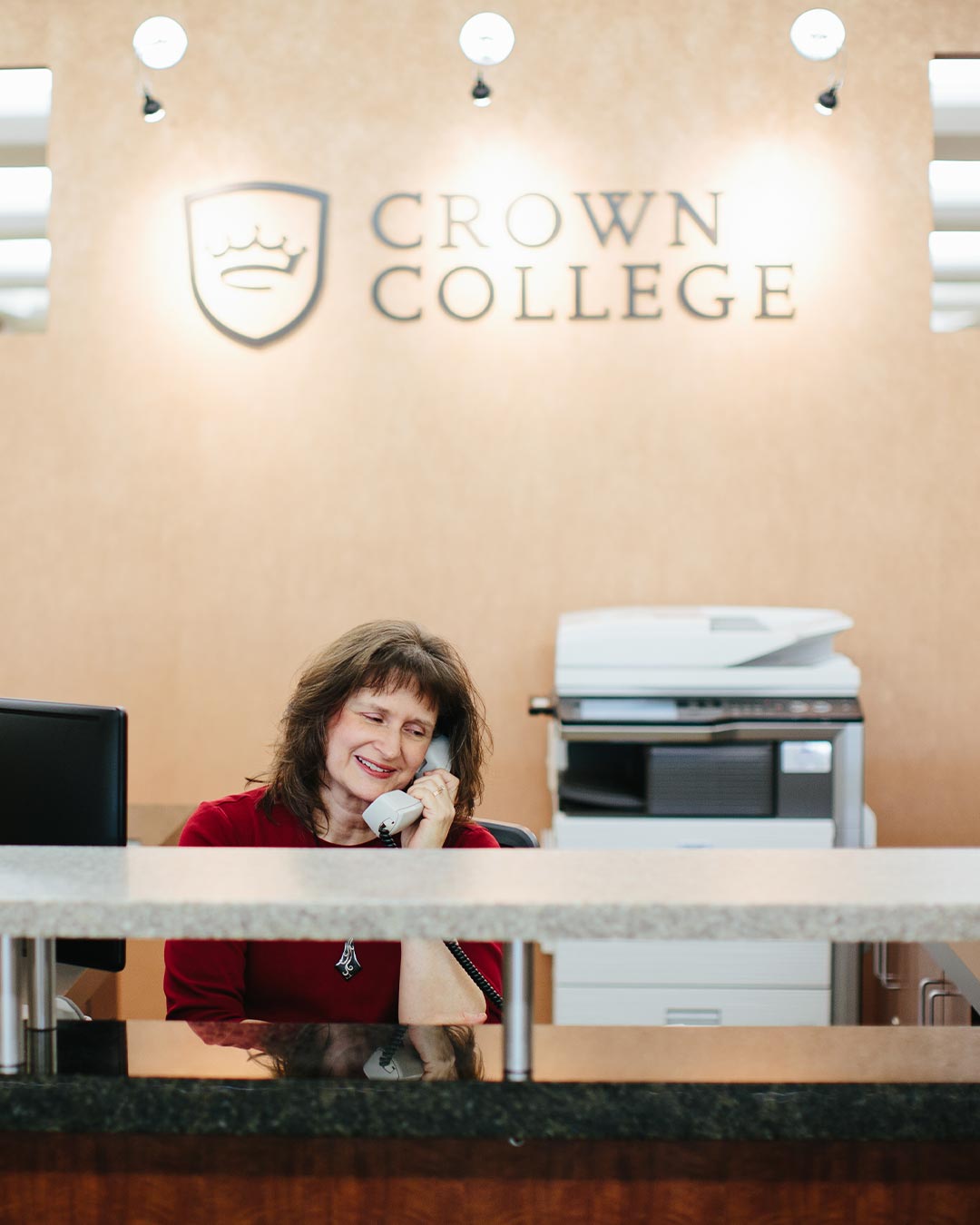 receptionist answering phone crown college admissions
