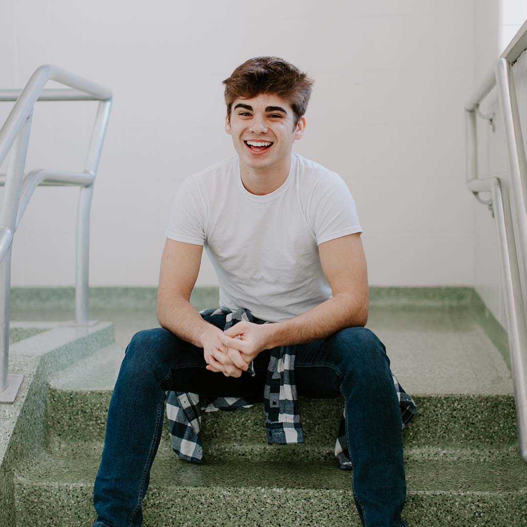 smiling student on steps of crown college